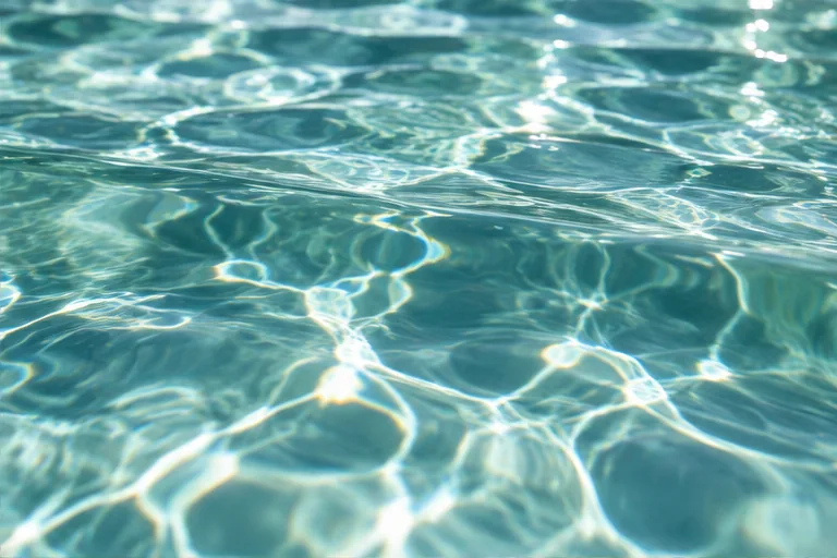 Agua turquesa cristalina con reflejos del sol